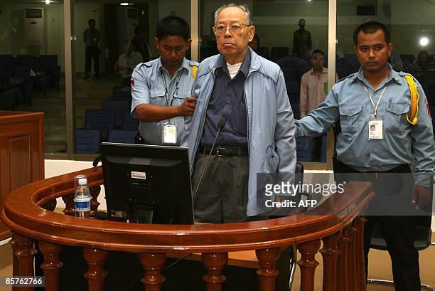 Former Khmer Rouge deputy Prime Minister and Minister of Foreign Affairs Ieng Sary stands in a dock in the courtroom during a public hearing of a...