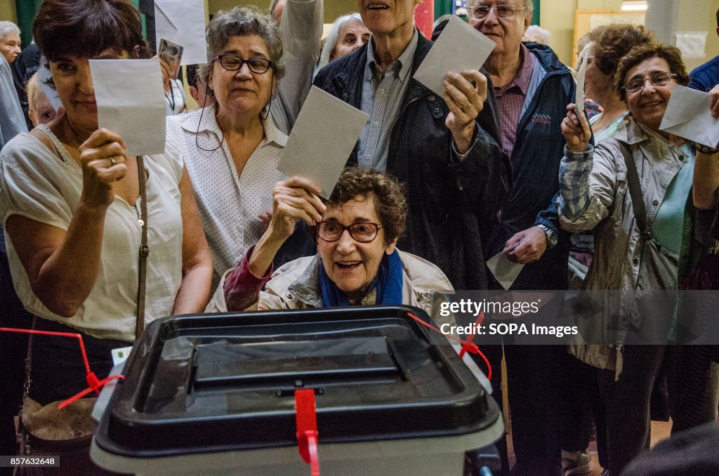 Several people seen holding up their ballot in a polling...