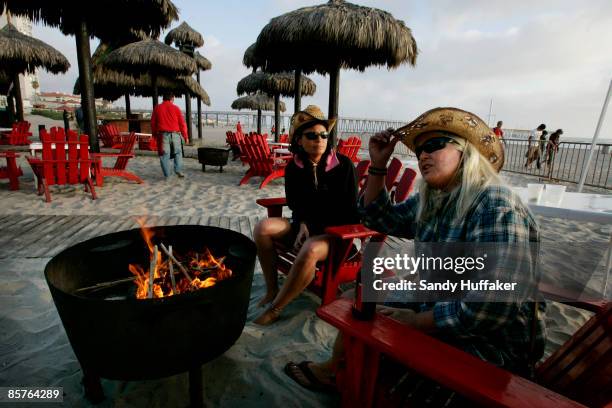 Carol Arthur and Tammy Delu, from Seattle, sit at a bar along the beach April 1, 2009 in Rosarito, Mexico. The tourist industry in some northern...