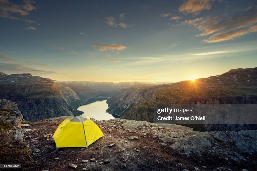 Tent on plateau overlooking fjord at sunset, Norway