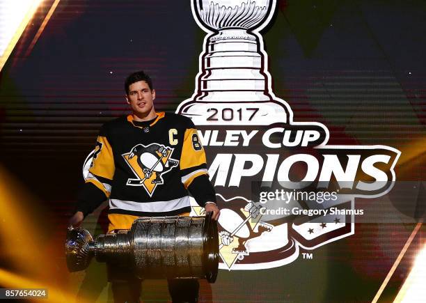 Sidney Crosby of the Pittsburgh Penguins brings the Stanley Cup to the ice before to raising their 2017 championship banner prior to playing the St....
