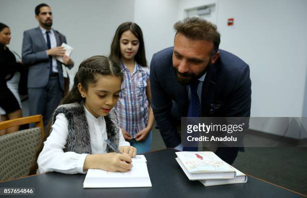 Bana Alabed , the 8-year-old Syrian girl who fled to Turkey from the war-torn Syrian city of Aleppo, signs her book named; 'Dear World: A Syrian...