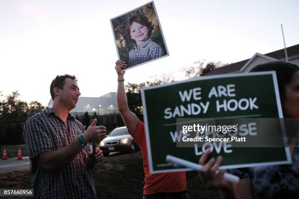 Mark Barden holds up a picture of his son Daniel who was killed in the Sandy Hook masracre during a vigil remembering the 58 people killed in...