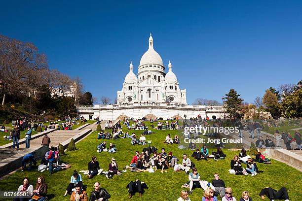 people lying on lawn in front of sacre coeur - basiliek sacre coeur stockfoto's en -beelden