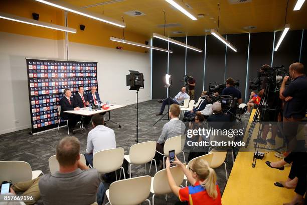 Mark Evans, Senior Coach Stuart Dew and Chairman Tony Cochrane speak to the media during a Gold Coast Suns AFL press conference at their training...