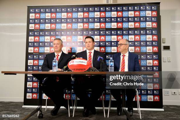 Mark Evans, Senior Coach Stuart Dew and Chairman Tony Cochrane speak to the media during a Gold Coast Suns AFL press conference at their training...