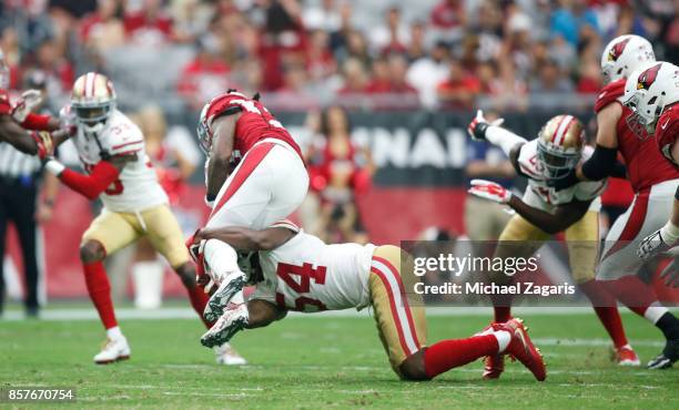 Ray-Ray Armstrong of the San Francisco 49ers tackles Andre Ellington of the Arizona Cardinals during the game at the University of Phoenix Stadium on...