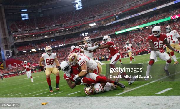 Kyle Juszczyk and Raheem Mostert of the San Francisco 49ers tackle Kerwynn Williams of the Arizona Cardinals during the game at the University of...