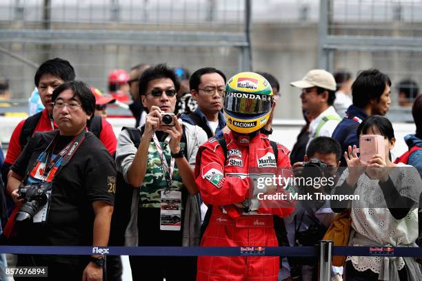 Fan dressed as Ayrton Senna looks on outside the Red Bull Racing garage during previews ahead of the Formula One Grand Prix of Japan at Suzuka...