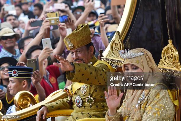 Brunei's Sultan Hassanal Bolkiah and Queen Saleha ride in a royal chariot during a procession to mark his golden jubilee of accession to the throne...