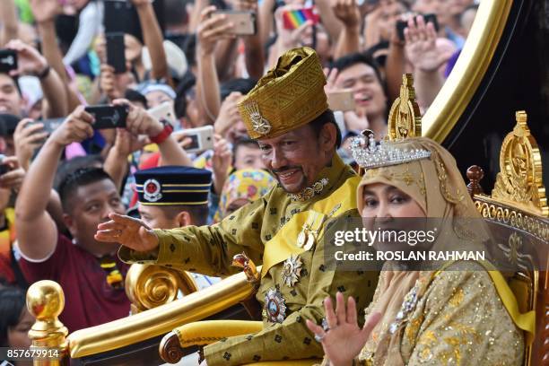 Brunei's Sultan Hassanal Bolkiah and Queen Saleha ride in a royal chariot during a procession to mark his golden jubilee of accession to the throne...