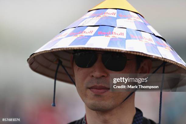 Red Bull Racing fan wears a traditional Japanese hat decorated with Red Bull logos during previews ahead of the Formula One Grand Prix of Japan at...
