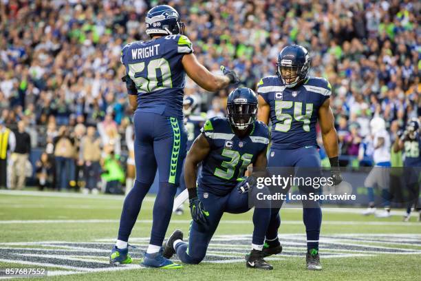 Wright , Kam Chancellor and Bobby Wagner of the Seattle Seahawks celebrate a defensive stop during a game between the Seattle Seahawks and the...