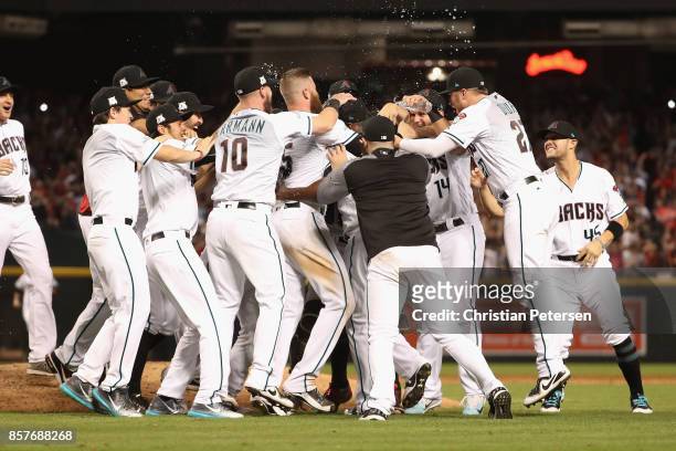 Chris Herrmann and Brandon Drury of the Arizona Diamondbacks celebrate with teammates after defeating the Colorado Rockies 11-8 in the National...