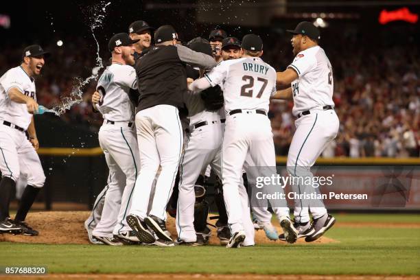 Brandon Drury and Yasmany Tomas of the Arizona Diamondbacks celebrate with teammates after defeating the Colorado Rockies 11-8 in the National League...