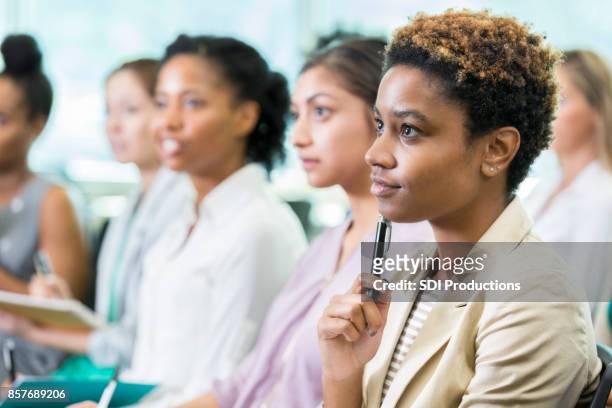 thoughtful woman attends business conference - group people thinking stock pictures, royalty-free photos & images