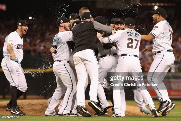 Brandon Drury and Yasmany Tomas of the Arizona Diamondbacks celebrate with teammates after defeating the Colorado Rockies 11-8 in the National League...