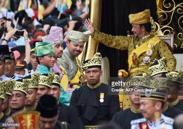 Brunei's Sultan Hassanal Bolkiah waves while Crown Prince Al-Muhtadee Billah , Prince Abdul Malik and Prince Abdul Wakeel look on from the royal...