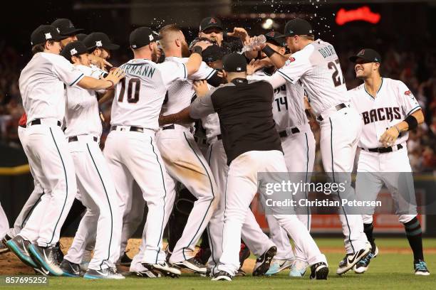 Chris Herrmann and Brandon Drury of the Arizona Diamondbacks celebrate with teammates after defeating the Colorado Rockies 11-8 in the National...