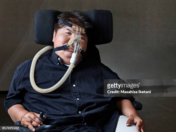 人工呼吸器をつけた車椅子の男性 - équipement d'assistance respiratoire photos et images de collection
