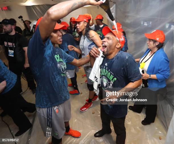 Rebekkah Brunson of the Minnesota Lynx pours champagne on assistant coach James Wade celebrating in the locker room after defeating the Los Angeles...