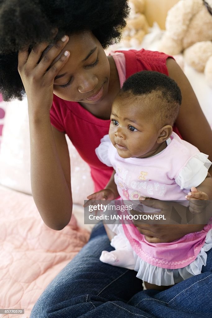 Stressed young mother holding her daughter (2-5 months)