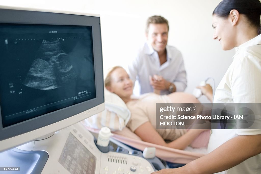 Doctor performing ultrasound on pregnant woman