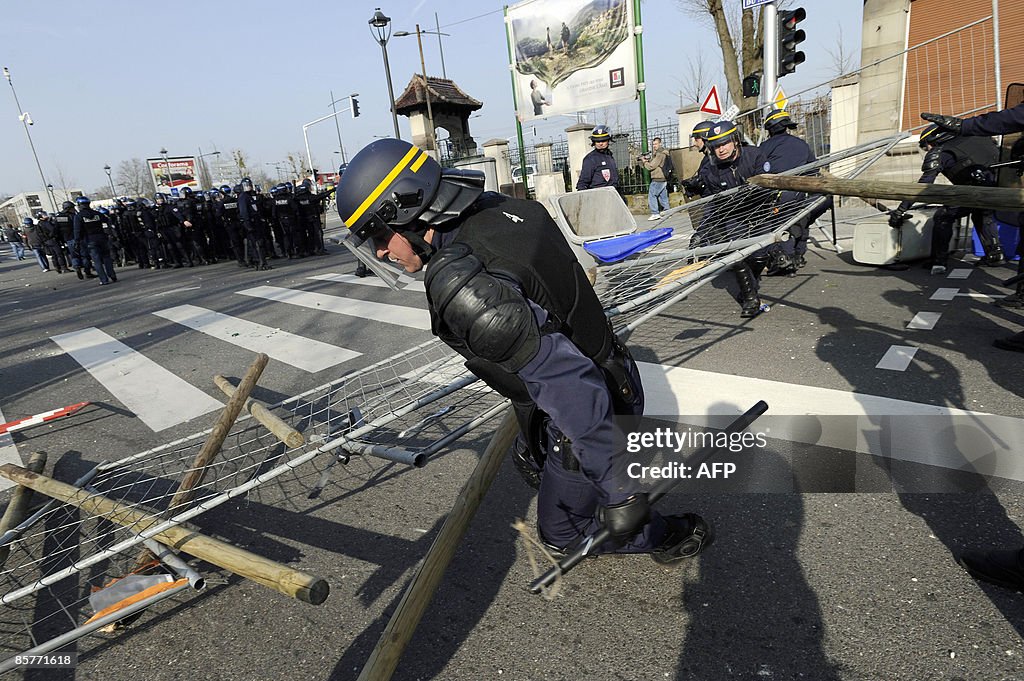 Anti-riot policemen clean a roadblock, o