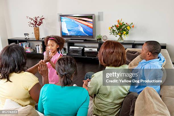 family watching tv - african american watching tv stock pictures, royalty-free photos & images