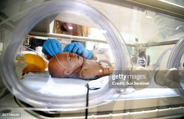 Instructor, Gloria Trujillo with University of Miami's simulation nursing programs, simulates working on a newborn at in the Neo-natal Intensive Care...