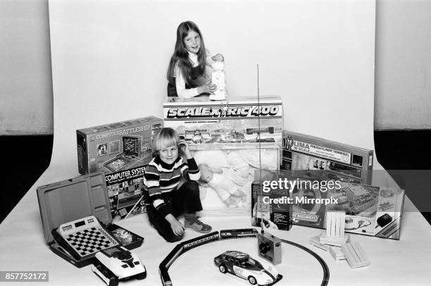 Young boy and girl with a selection of children's toys for Christmas, December 1980.