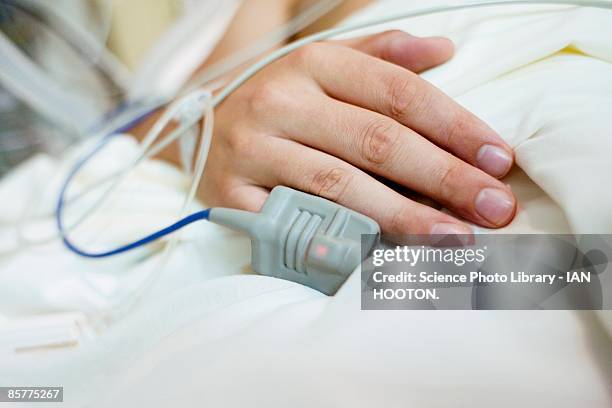close-up of a patient's hand in a hospital bed - unconscious fotografías e imágenes de stock
