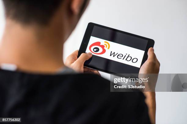 Man holds an Apple iPad Mini as he uses Weibo app on October 4, 2017 in Hong Kong, Hong Kong.