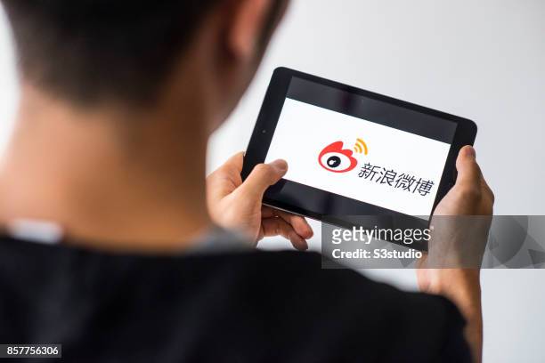 Man holds an Apple iPad Mini as he uses Weibo app on October 4, 2017 in Hong Kong, Hong Kong.