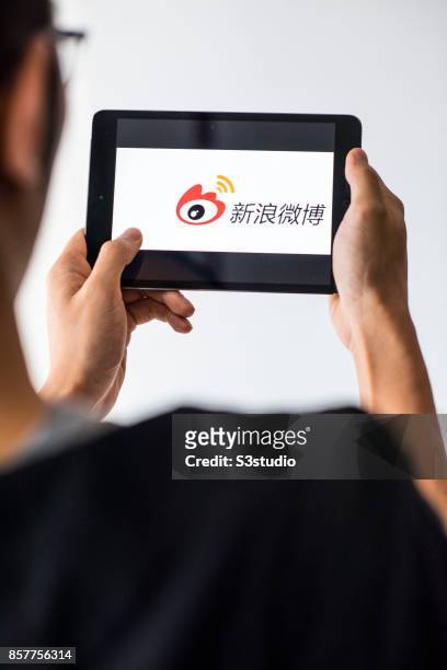 Man holds an Apple iPad Mini as he uses Weibo app on October 4, 2017 in Hong Kong, Hong Kong.