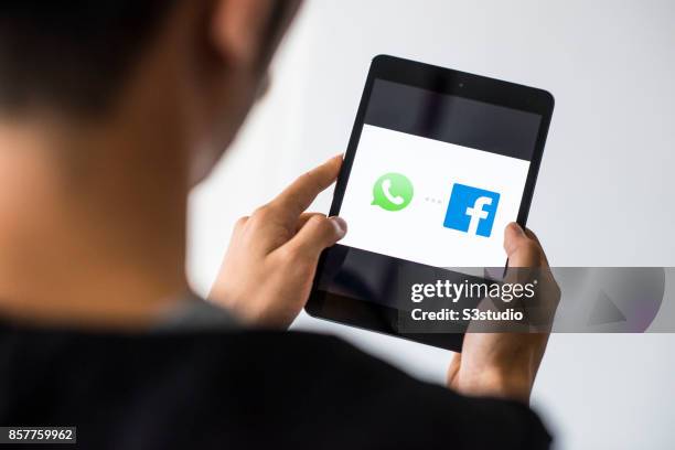 Man holds an Apple iPad Mini as he uses WhatsApp and Facebook apps on October 4, 2017 in Hong Kong, Hong Kong.