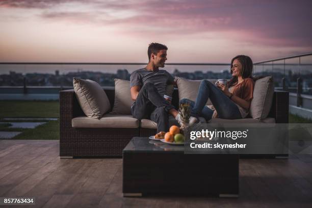 feliz pareja relajarse en un patio en el crepúsculo y comunicación. - té terraza fotografías e imágenes de stock