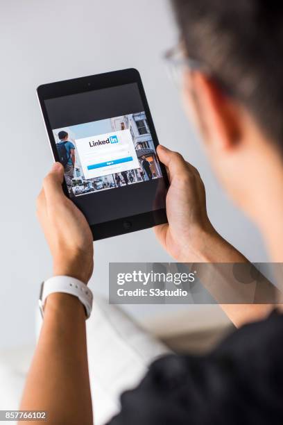 Man holds an Apple iPad Mini as he uses LinkedIn app on October 4, 2017 in Hong Kong, Hong Kong.