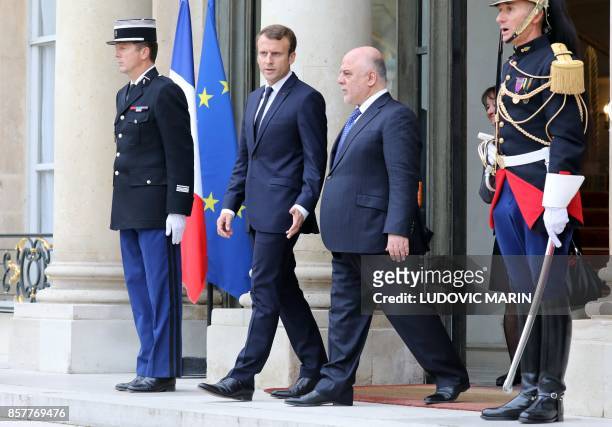 French president Emmanuel Macron escorts Iraqi Prime minister Haider al-Abadi out of the Elysee palace after their meeting in Paris, on October 5,...