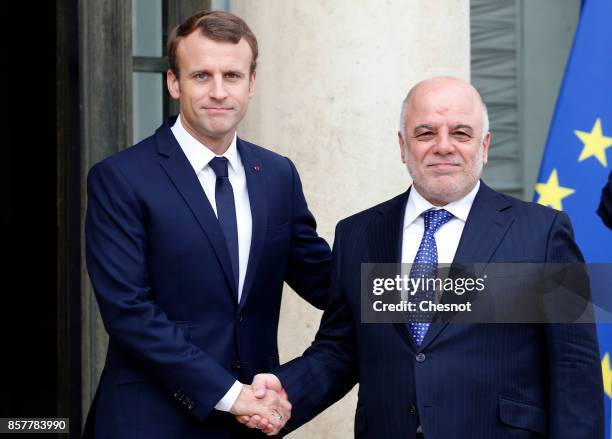 French President Emmanuel Macron welcomes Iraq's Prime Minister Haidar Al-Abadi prior to their meeting at the Elysee Presidential Palace on October...