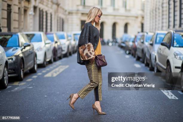 Gitta Banko wearing a mustard colored sweater from Mango, brocade jacket with fake fur trimming in leopard pattern by Steffen Schraut, pants with...