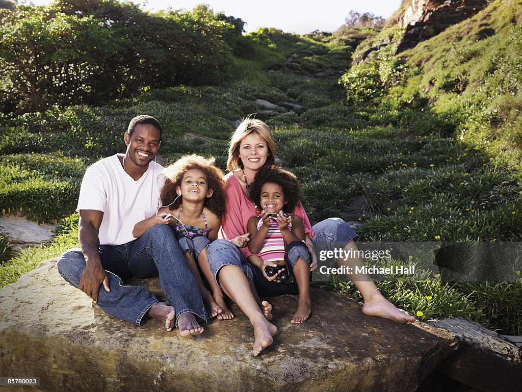 Family sitting on boulder