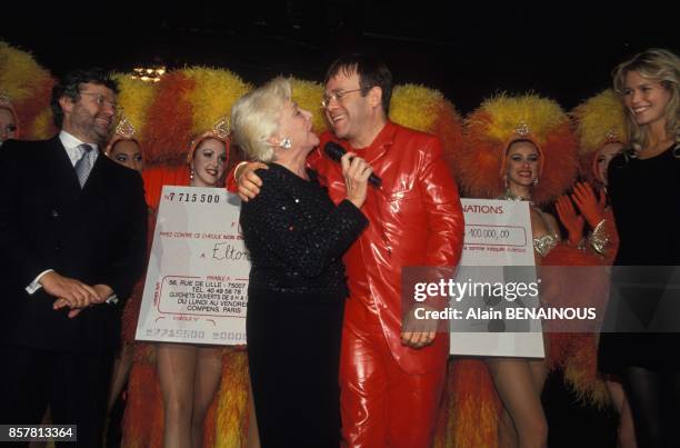 Alain-Dominique Perrin, Line Renaud, Elton John and Claudia Schiffer at party against AIDS at the Moulin Rouge cabaret on October 11, 1994 in Paris,...