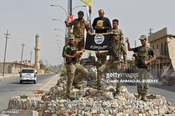 Members of the Iraqi forces, which are backed by fighters from the Hashed al-Shaabi , pose for a photograph in Hawija on October 5 after retaking the...