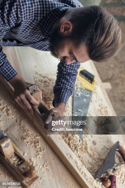 hipster carpenter milling a plank - milling cutter stock pictures, royalty-free photos & images