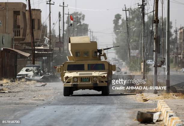 Iraqi forces, which are backed by fighters from the Hashed al-Shaabi , advance through Hawija on October 5 after retaking the city from Islamic State...
