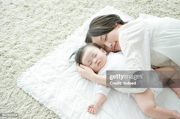 mother and baby girl sleeping together - asian sleeping stock pictures, royalty-free photos & images