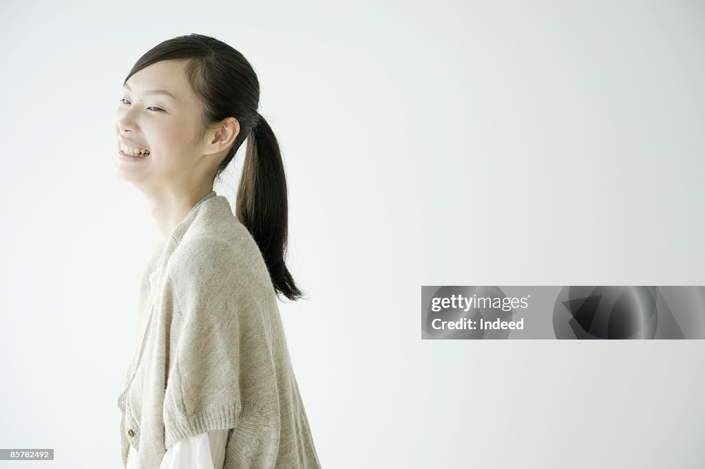 Japanese young woman laughing, side view