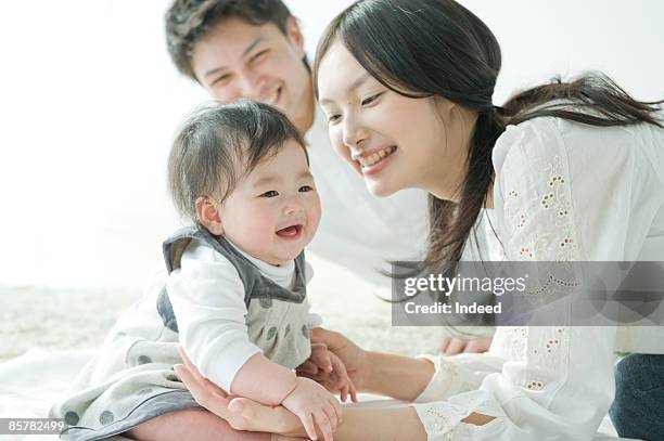 parents smiling and looking at baby girl - only japanese bildbanksfoton och bilder