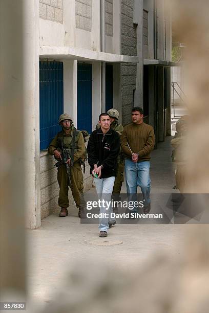 Israeli soldiers detaine Palestinians for questioning March 12, 2002 on the grounds of the United Nations school of the al-Amari refugee camp in the...